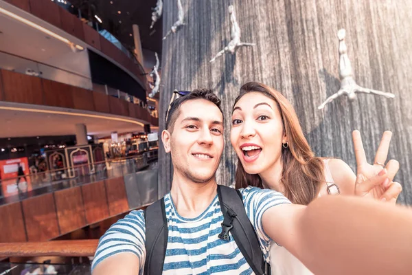 26 november 2019, Uae, Dubai: Happy Par tar selfie foto vid det berömda vattenfallet med hoppande män i Dubai Mall. Turistmål — Stockfoto