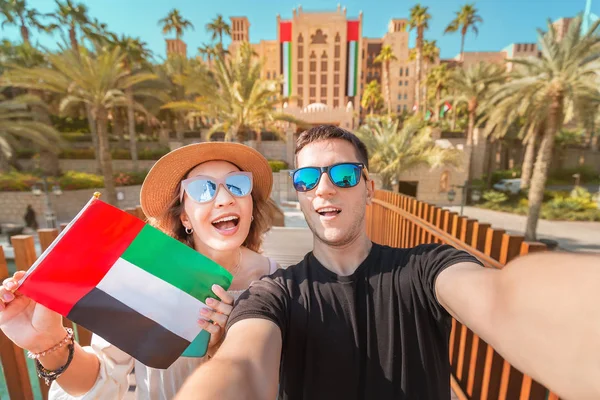 Селфи любящей пары мужчин и женщин с национальным флагом ОАЭ. Концепция путешествий и иммиграции в Дубае и Объединенных Арабских Эмиратах — стоковое фото