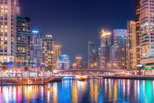 Noite vista colorida da famosa atração turística da cidade de Dubai - Marina porto e arranha-céus iluminados. Viagens e turismo em Emirados Árabes Unidos — Fotografia de Stock
