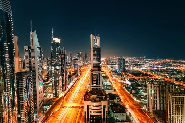 Night view of the spectacular landscape of Dubai with high-rises and skyscrapers at the Sheikh Zayed highway. Global travel destinations and real estate concept