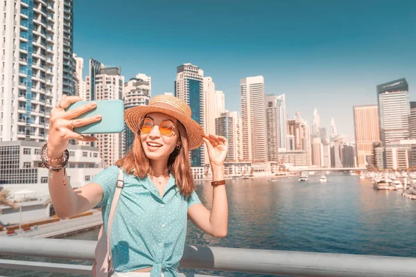 Happy Asian tourist girl takes selfie photos in popular Marina district in Dubai for her social media and blog — Stock Photo, Image