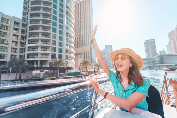 Азиатка на круизном лайнере машет рукой с небоскребами порта Марина в Дубае — стоковое фото