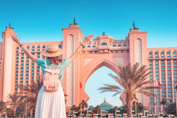 Happy asian girl traveller with backpack enjoying view of the famous luxury Atlantis hotel building on a Jumeirah Palm Island in Duba, UAE — Stock Photo, Image