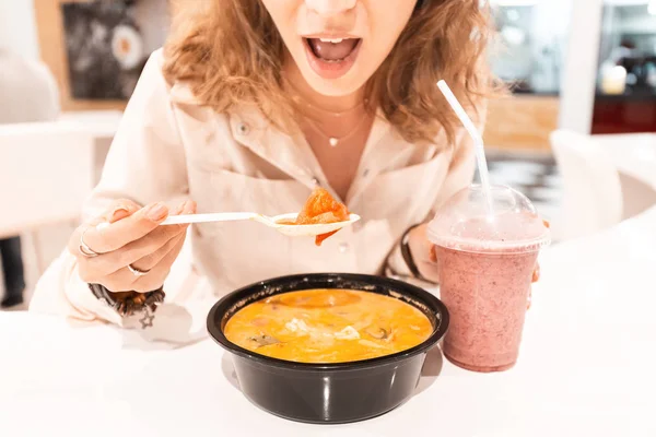 Girl eating Asian soup in foodcourt fast food cafe — Stock Photo, Image