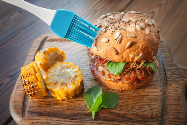 Bir şef ya da fotoğrafçı fotoğraf çekiminden önce bir hamburgeri yağlamak için bir fırça kullanır. Hile ve hayat mücadelesi yemeğin parlamasını ve lezzetli görünmesini sağlar.