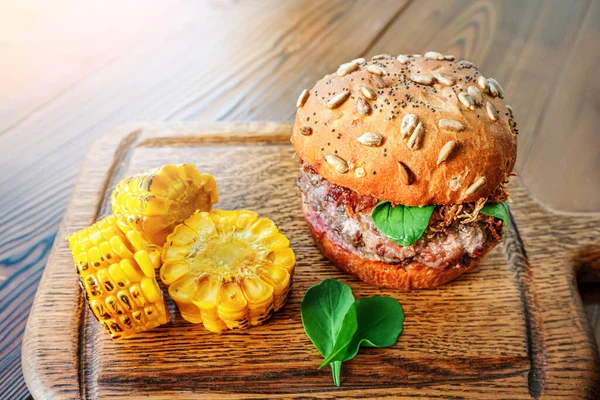 Lezzetli ve sulu Burger Amerikan fast food ve süper kalori diyetinin bir sembolü. Tahta bir arka planda kurulda görev almış..