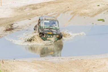 Off-road. Off-road yarışmasında 4x4 'lük araç nehirden su sıçratıyor.