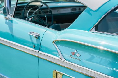 19 Nisan 2019 'da İngiltere' nin Rushmoor şehrinde klasik bir Amerikan aracının Chevrolet Impala rozeti ve krom kapılı paneli.