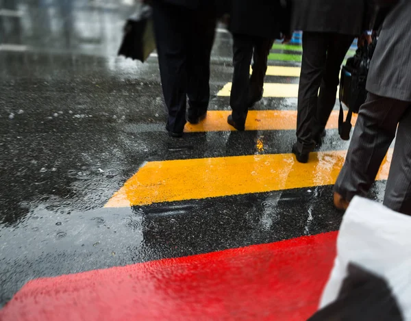 Ludzie przejść ulicę w deszczowy dzień — Zdjęcie stockowe