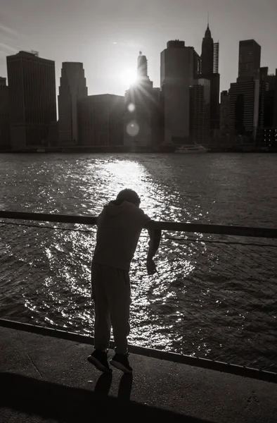 Silueta de un niño de pie en el terraplén de East River — Foto de Stock