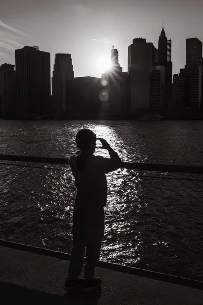 Silueta de un niño de pie en el terraplén de East River —  Fotos de Stock
