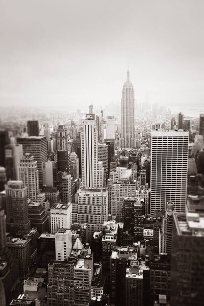 New York City Manhattan midtown aerial view with skyscrapers on an overcast day. Sepia toned image with a blurred foreground. Old photo stylization, film grain added. Sepia toned