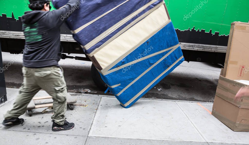 Young man unload furniture from the truck