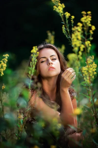 Retrato de uma jovem mulher no campo de flores — Fotografia de Stock