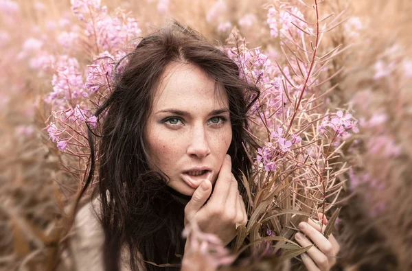 Vacker flicka bland blommorna — Stockfoto