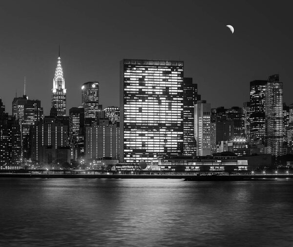 Manhattan at Night. New York City skyline with lights and reflections. Black and white image