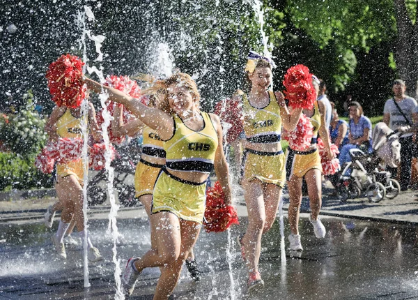Group of happy Cheerleaders enjoy jogging through the fountain — Stock Photo, Image