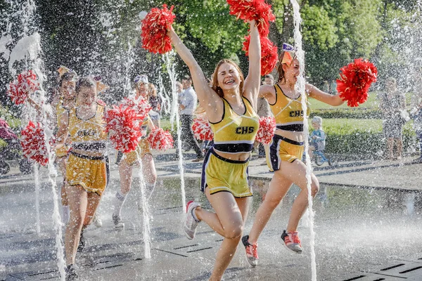 Grupo de animadoras felices disfrutan corriendo a través de la fuente —  Fotos de Stock