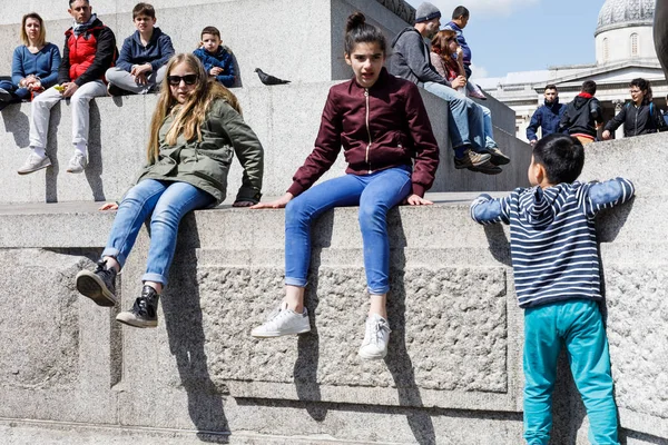 Erwachsene und Kinder ruhen sich am Fuß der Nelson-Säule aus — Stockfoto
