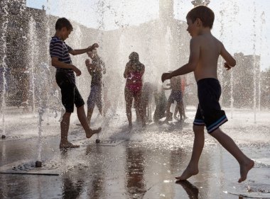 Mutlu çocuklar çeşmeden su sıcak bir günde oyun