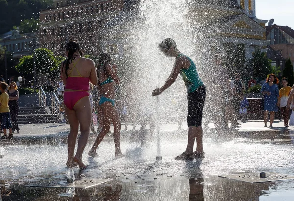 Χαρούμενα παιδιά που παίζουν σε μια πηγή νερού σε μια καυτή ημέρα — Φωτογραφία Αρχείου