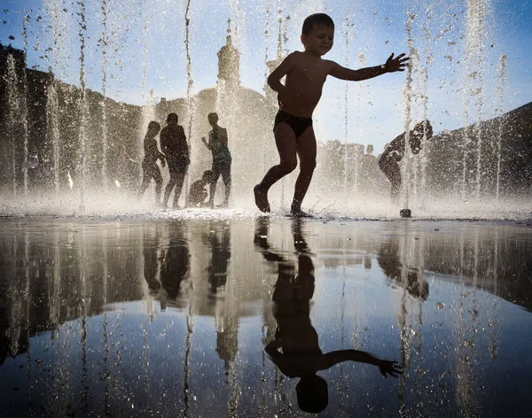 快乐的孩子们在喷泉打在大热天 — 图库照片