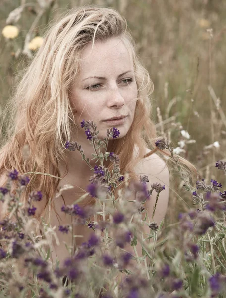 Artistic portrait of freckled woman on natural background
