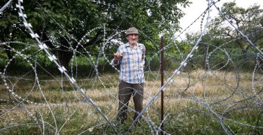 Old man on local stand near barbed wire clipart