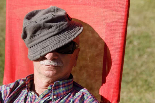 An elderly man enjoys relaxing on the sun — Stock Photo, Image