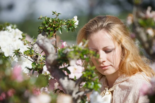 Blond flicka bland blommor — Stockfoto