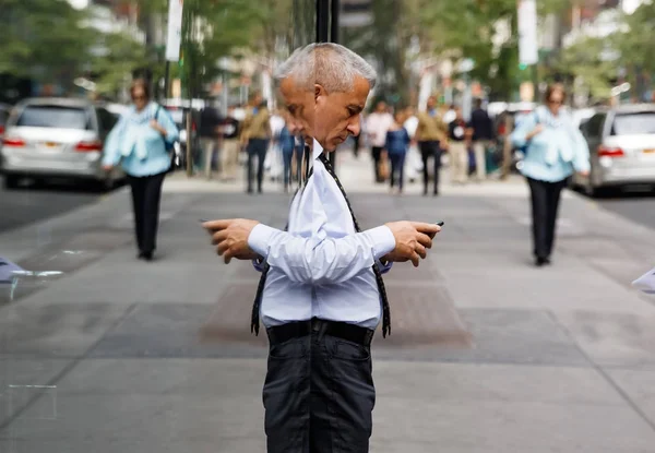 Elderly gray-haired man with a mobile phone in NYC — Stock Photo, Image