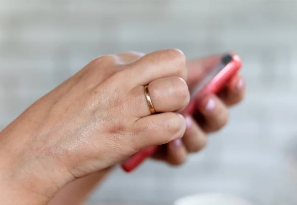 Mobile phone in a woman's hand — Stock Photo, Image