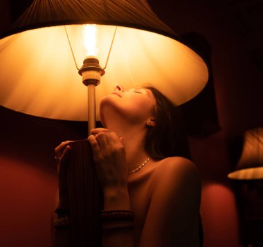 Eski dekoratif mobilyalarda çıplak esmer poz veriyor.