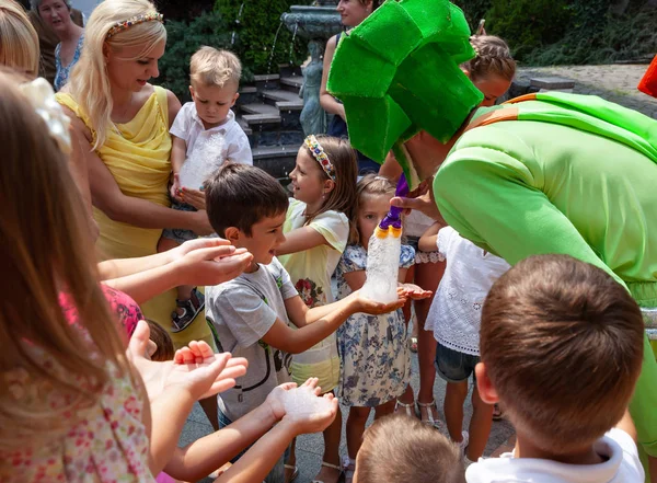 Clowns show soap bubbles to children — Stock Photo, Image