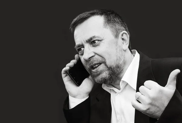 Homem de negócios fala em um telefone celular — Fotografia de Stock