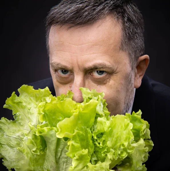 Człowiek posiadający i jedzenie sałaty — Zdjęcie stockowe