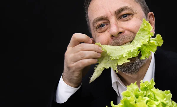 Mannen innehar och äta sallad — Stockfoto