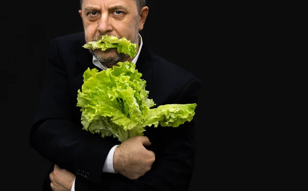 Hombre sosteniendo y comiendo lechuga —  Fotos de Stock