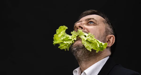 Homem segurando e comendo alface — Fotografia de Stock