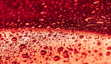 Kırmızı bir yüzeye yağmur damlaları düşer