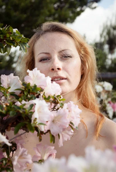 Ung kvinna bland blommorna i azalea — Stockfoto