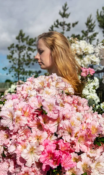 Fiatal nő között a virágok azálea — Stock Fotó