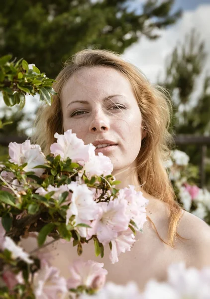 Junge Frau inmitten der Azaleen-Blüten — Stockfoto