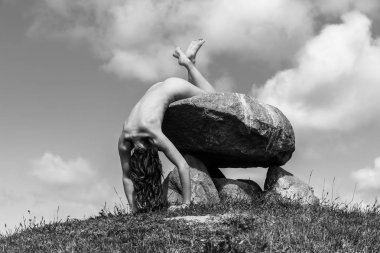 Tepenin tepesinde çıplak bir kadın poz veriyor.