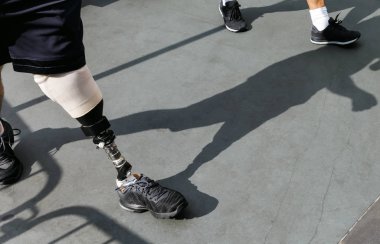 Disabled young man with foot prosthesis clipart