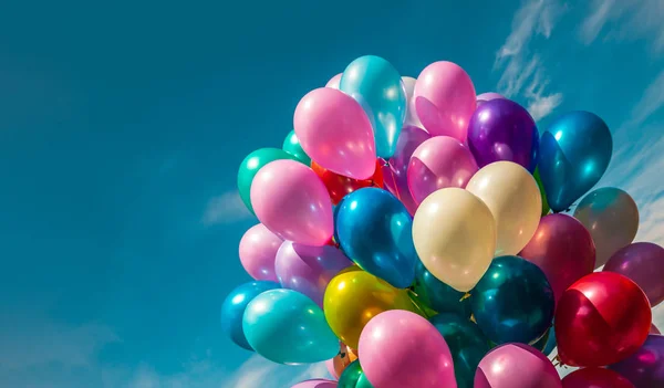Mavi gökyüzü arka plan üzerinde çok renkli balonlar — Stok fotoğraf