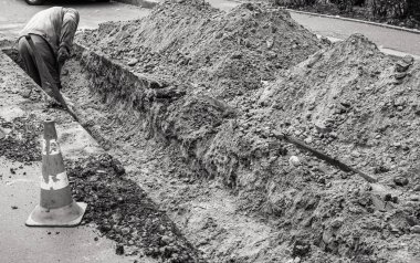 KYIV, UKRAINE - Sep 28, 2019: Worker with shovel in a trench, dig trenches along the road