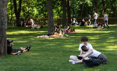 Kyiv, Ukrayna - Haziran. 06, 2019: Volodymyrska Hill veya Kyiv 'deki Saint Volodymyr Hill. Gençler parkta çimlerin üzerinde dinleniyorlar..
