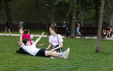 Kyiv, Ukrayna - Haziran. 06, 2019: Volodymyrska Hill veya Kyiv 'deki Saint Volodymyr Hill. Gençler parkta çimlerin üzerinde dinleniyorlar..