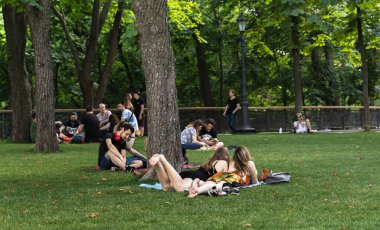 Kyiv, Ukrayna - Haziran. 06, 2019: Volodymyrska Hill veya Kyiv 'deki Saint Volodymyr Hill. Gençler parkta çimlerin üzerinde dinleniyorlar..